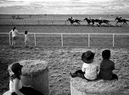 Unos niños observan una carrera de caballos en Mawelton, Australia.