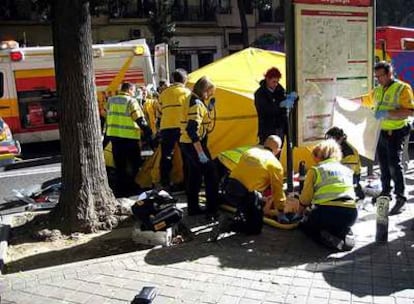 Los servicios de emergencias atienden en plena calle a uno de los heridos en la reyerta.