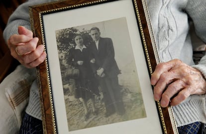 María Josefa Guillén, de 103 años, muestra una foto antigua donde aparece junto a su marido cuando eran jóvenes, en su casa de Cazalla (Sevilla).