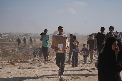 Un ciudadano palestino trasporta una caja que contiene comida repartida por la Fundación Humanitaria para Gaza, este martes en Rafah. 