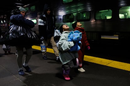 Leannysmar Ruiz, de 7 años, y su hermana Lismar Ruiz, de 6, tratan de ver su aliento en el aire mientras caminan con otros migrantes después de viajar en el metro de Chicago