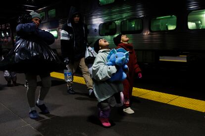 Leannysmar Ruiz, de 7 años, y su hermana Lismar Ruiz, de 6, tratan de ver su aliento en el aire mientras caminan con otros migrantes después de viajar en el metro de Chicago