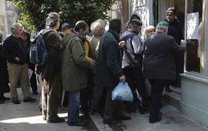 Un grupo de personas hace cola en el exterior de un comedor social en Atenas. El Parlamento de Grecia ha aprobado hoy un partida presupuestaria de 200 millones de euros para atender a personas en situaci&oacute;n de extrema pobreza. 