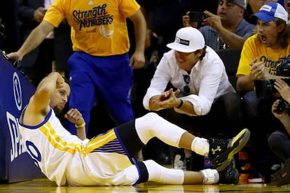 Stephen Curry celebra una canasta tendido sobre el parquet.