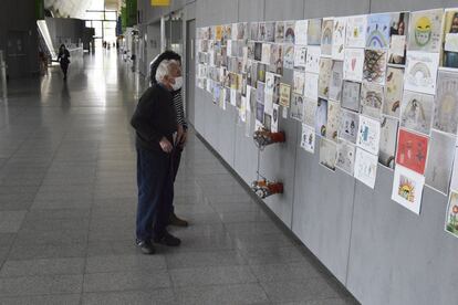 Dos personas miran los dibujos, imágenes y escritos de soporte a los enfermos y a los profesionales del Hospital Sant Joan de Reus recogidos por el centro y que ahora, unos 2.000 en total, han sido donados al Arxiu Municipal de Reus dentro de la campaña #arxivemlacovid19 promovida por la AAC.