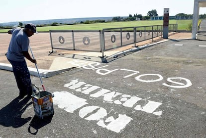 Homem remove frase "Fora Temer Golpista" pintada em frente ao Palácio do Alvorada, em Brasília, nesta quinta.