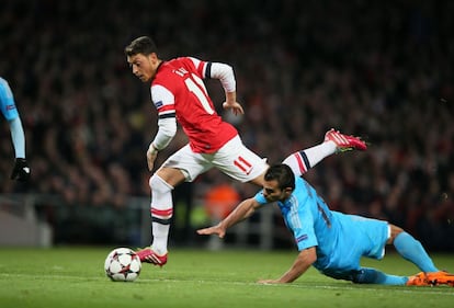 Mesut Özil supera al jugador del Olympique Jeremy Morel.