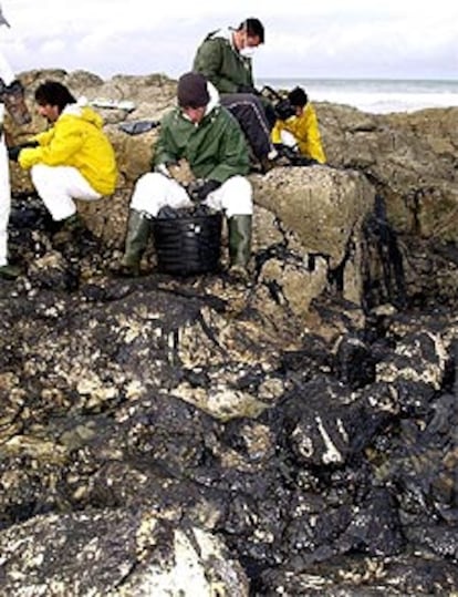 Operarios de Tragsa siguen limpiando la playa de La Maruca, uno de los puntos de la costa cántabra aún afectados.