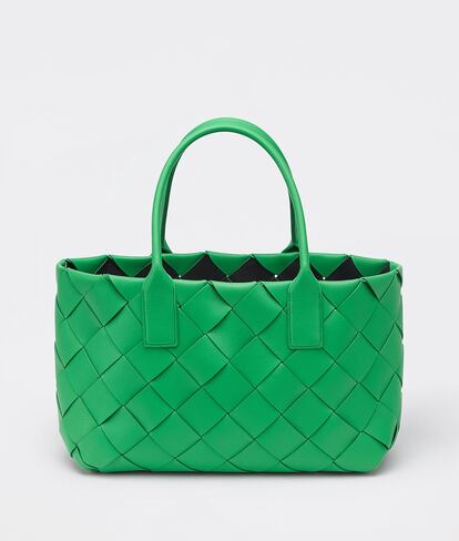 Las nuevas creaciones de Bottega Veneta transmiten toda la energía positiva de la llegada de la próxima estación: colores vibrantes, entre los que destaca el verde, y evocación floral. El bolso Cabat, en tamaño maxi, está confeccionado a base de su icónico 'intrecciato' en piel de napa. Está disponible en tres tonos diferentes; en la imagen, verde hierba con acabados dorados. Incluye un pequeño bolso de tamaño reducido, anclado mediante una cadena, para recoger las llaves, la cartera o lo que se necesite más a mano. Precio: 3.500 euros.