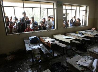 Un grupo de niños ve lo que quedó de un salón de clase en un colegio en Ciudad Sáder