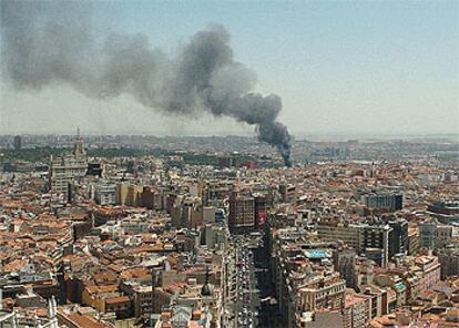 Una densa columna de humo, visible desde 50 kilómetros, cubrió el cielo de la capital, como se aprecia en la foto, tomada desde un rascacielos de la plaza de España.