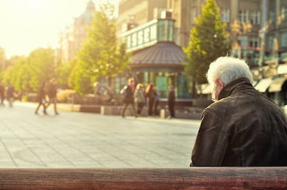 Un hombre descansa en un banco. 