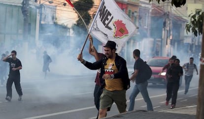 Manifestantes corren enate el lanzamiento de gases lacrim&oacute;genos.