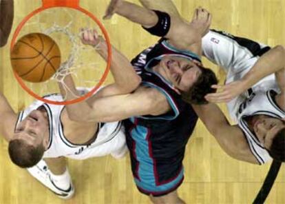 Gasol, bajo la canasta entre dos jugadores del San Antonio Spurs.