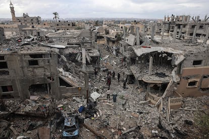 Palestinians inspect the destruction caused by Israeli strikes on their homes in the village of Khuzaa, east of Khan Yunis