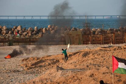 Un manifestante palestino lanza un cóctel molotov en una playa junto a la frontera con Israel en Gaza.