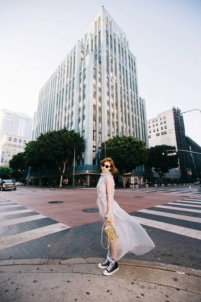 En el Downtown con vestido transparente de Clean by Kling, body de American Apparel, bolso metalizado 'Petite Malle' de Louis Vuitton, zapas negras Converse Chuck Taylor All Star y gafas modelo Gatsby de Ray-Ban. Con textura de lipgloss, Lourdes lleva el tono Nº5 Rouge Laque de Vernis à Lèvres Vinyl Cream de YSL Beauté.