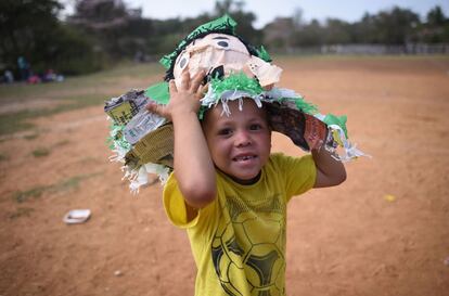 Un niño que camina con su familia en el Viacrucis migrante posa ante la cámara con los restos de la piñata.
