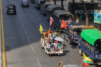 Simpatizantes del ejército pasan cerca de vehículos policiales en una calle en Yangon, este lunes.