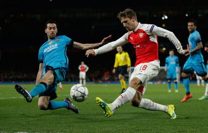 Busquets disputa el balón con Monreal.