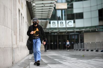 Un hombre con mascarilla pasa frente a la sede de la BBC en Londres.