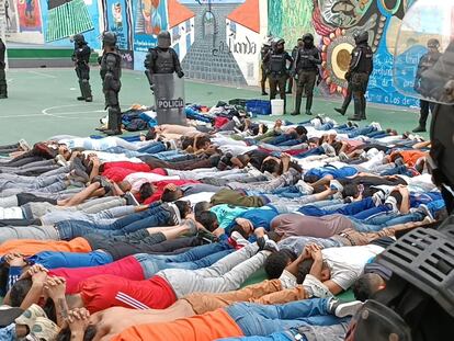 Decenas de presos, vigilados por agentes de la policía, acostados en el patio de la cárcel del Inca de Quito.