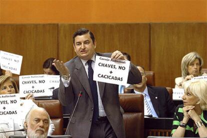 El portavoz popular, Antonio Sanz, con un cartel alusivo a Chaves, en la sesión de control al Gobierno regional.