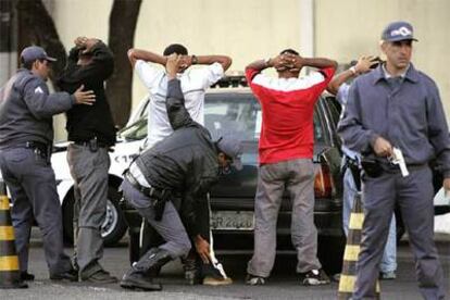 Policías de São Paulo registran a varios hombres, en los disturbios de mayo
