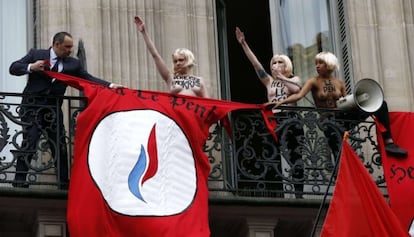 Un guardia de seguridad quita la bandera "Heil Le Pen" puesta por activistas de Femen en Paris.