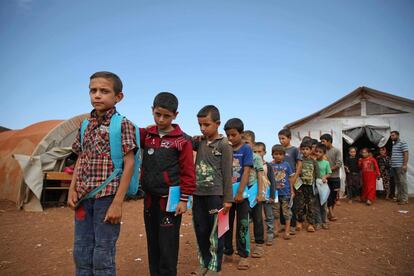 Un grupo de niños sirios permanece en fila a la salida de una de las aulas de la escuela.