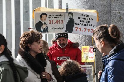 Un vendedor ambulante de lotería apostado en el centro de Madrid. Raphael y Julio Iglesias actúan como reclamo publicitario.