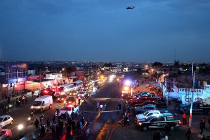 Agentes de la Fiscalía de Jalisco y de la policía municipal en el sitio donde se incendió un camión para bloquear una vialidad de Zapopan.