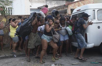 Ocupas ilegales se ponen a cubierto de las granadas de aturdimiento y gases lacrimógenos en un desalojo en Río de Janeiro, Brasil.