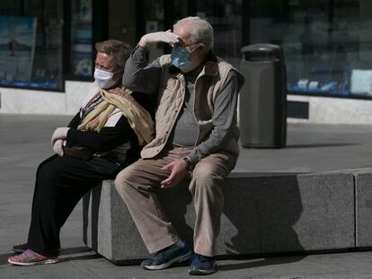 Dos personas con mascarillas en una calle de Madrid.
