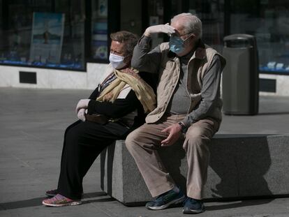 Dos personas con mascarillas, en una calle de Madrid.