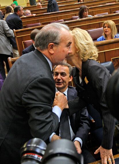 Pedro Solbes y la que será su sucesora, Elena Salgado, se saludan junto al escaño del presidente Zapatero, durante el primer debate sobre el estado de la naciñon celebrado el 13 de mayo de  2009 y con la situación económica como principal eje.