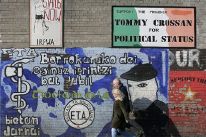 Una pareja pasa ante un mural de apoyo a ETA en Falls Road, en el barrio católico de Belfast.