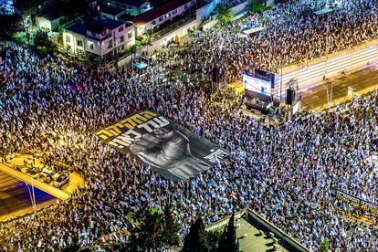 Protesters hold a banner as they take part in a demonstration against Israeli Prime Minister Benjamin Netanyahu and his nationalist coalition government's judicial overhaul, in Tel Aviv, on June 17, 2023