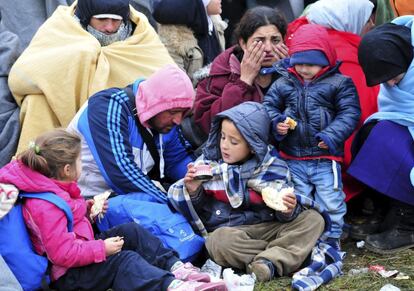 As condições de higiene tendem a deteriorar durante o inverno, pois os refugiados e migrantes não encontram lugares para se higienizar e lavar a roupa, o que leva a um aumento de doenças cutâneas. Nesta foto, algumas crianças e suas famílias comem pão e conservas em lata enquanto esperam na fronteira com a Croácia em Rigonce (Eslovênia) em 23 de outubro de 2015.