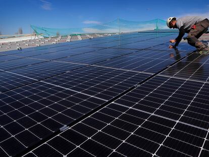Montaje de estructuras de placas solares en el tejado de una industria española.