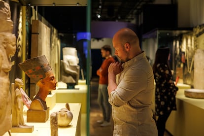 Un hombre observa un busto egipcio en la exposición.