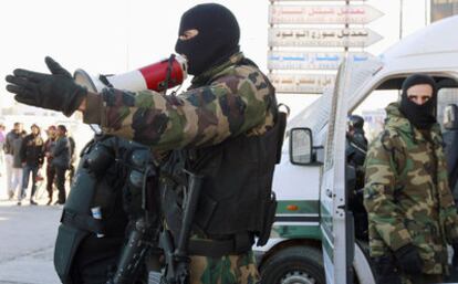 Un soldado hace un llamamiento para que se dispersen los manifestantes que se reunieron ayer en el barrio tunecino de Ettadamen.
