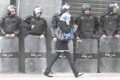 Una mujer pasa delante de agentes antidisturbios desplegados en Argel para reprimir la manifestación del sábado.