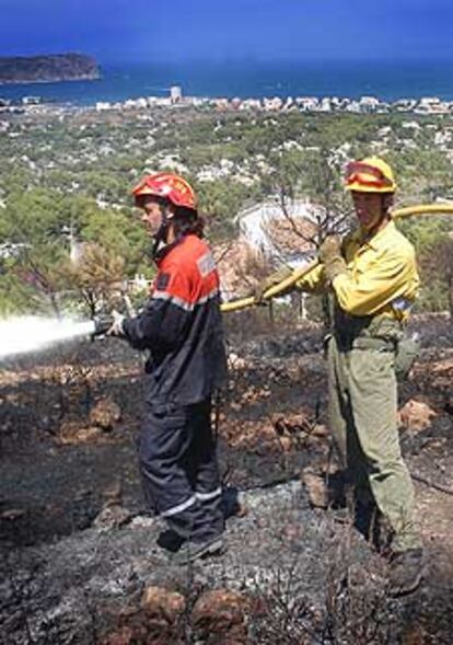 Dos bomberos extinguen los restos del incendio declarado ayer en Xàbia.