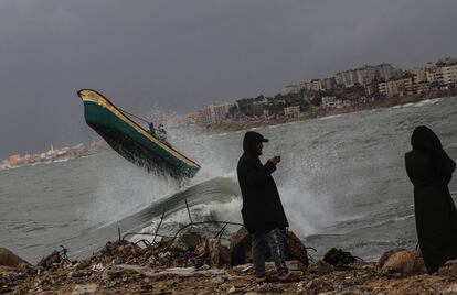 Un barco pesquero supera una ola durante una jornada lluviosa en Gaza.