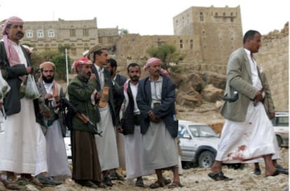 Varios hombres observan el paso de otro cuya vestimenta está manchada de sangre en la población de Kohal, ubicada en una provincia de mayoría chií a 50 kilómetros de Saná, la capital yemení.