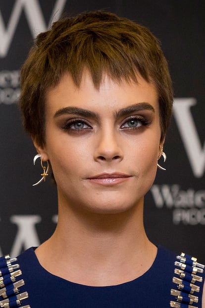 El nuevo look de Cara Delevingne pasa por un 'pixie cut' que deja el rubio a un lado. En su lugar se ha decantado por un tono chocolate que se lleva a las mil maravillas con ahumados en estos tonos.