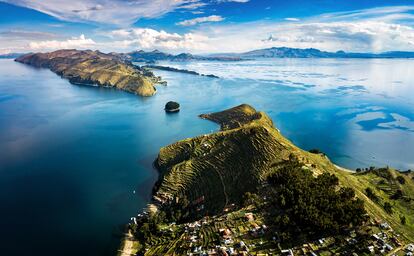 Isla del Sol (Bolivia) parece flotar en el cielo. Está situada a una impresionante altura (3.812 metros sobre el nivel del mar) sobre la superficie de agua navegable más alta del mundo, el lago Titicaca. Aunque estuvo ocupada al menos desde el año 2.200 antes de Cristo, su periodo de gloria fue en el siglo XV, durante el imperio Inca, cuando se levantaron la mayoría de las 80 construcciones que hoy vemos en ruinas. La isla no tiene carreteras y la mayoría de sus áridas laderas están cubiertas por campos agrícolas en terrazas plantadas de quinoa. Las 800 familias de la isla viven en el pueblo más al sur de Yumani, un centro para el turismo, con casas de huéspedes tradicionales y vistas a las aguas azules del Titicaca. Los caminos de tierra conducen desde aquí al norte a través de colinas interiores salpicadas de sol hasta los asentamientos de Cha’lla y Challapampa (su pequeño museo tiene interesantes figurillas de oro y plata de origen tiahuanaco e inca). También se pueden visitar el laberinto de Chincana y la llamada Escalera del Inca, con peldaños de piedra que se elevan cuesta arriba desde el muelle del ferri en Yumani. O las ruinas de Pilko Kaina, las más llamativas, del lado sur de la isla, que se cree que fueron construidas para el emperador inca Túpac Yupanqui. Una buena opción de senderismo es hacer el camino de Yumani a Cha’llapampa pasando por colinas escalonadas y miradores con vistas a los picos nevados de la Cordillera Real.