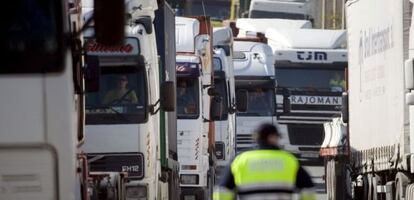 Un polic&iacute;a portuario controla el acceso de los centenares de camiones que congestionan la carretera V-30 en el acceso al Puerto de Valencia. EFE/Archivo