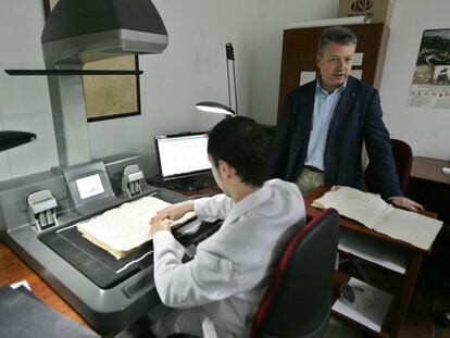 Primo Jurado, de pie, ayer en el Palacio de Viana junto a un trabajador que digitaliza un legajo.